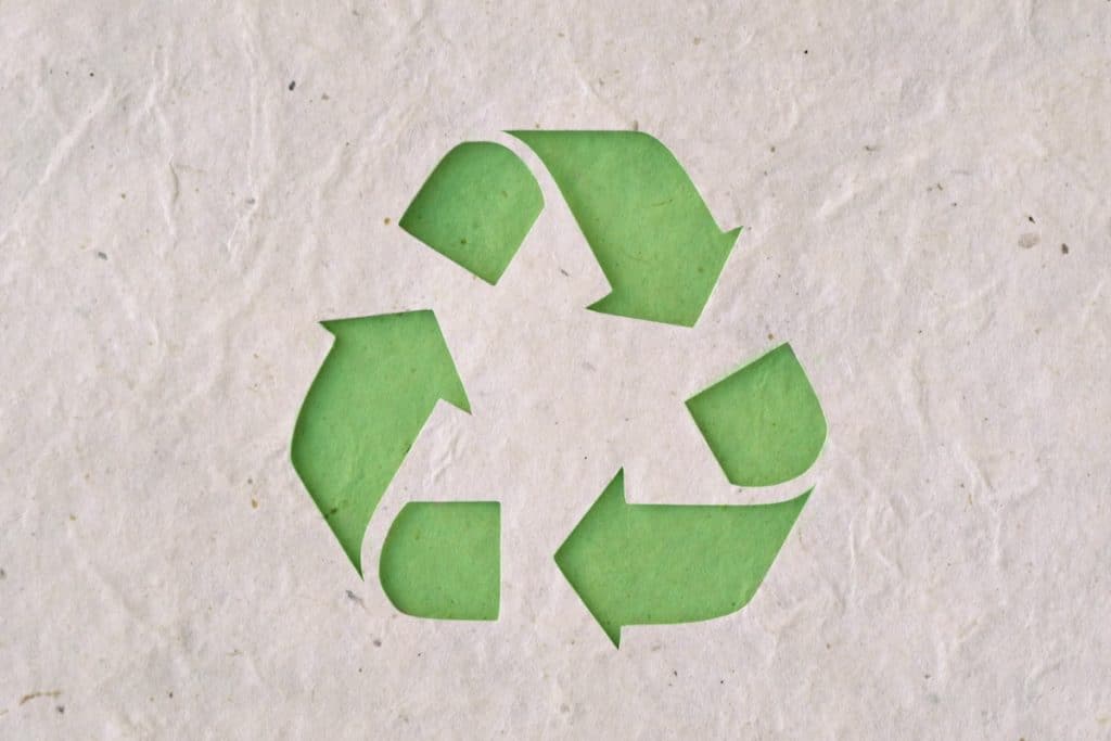 Un symbole de recyclage vert sur un morceau de papier.