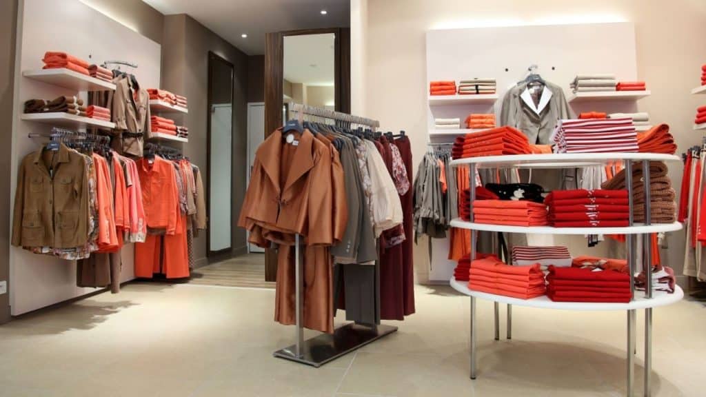 Un magasin de vêtements pour femmes avec des vêtements orange exposés.